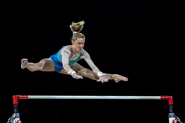 Sports photograph showing gymnast on uneven bars
