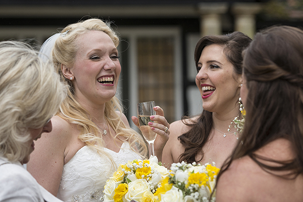 Beautiful Wedding photograph taken as bride sips champagne with friends